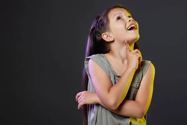 Petite fille réfléchie enfant sur fond noir. — Photo