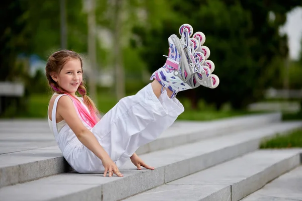 Schattig klein meisje op rolschaatsen in park. — Stockfoto