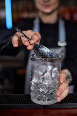 Profesyonel erkek barmen alkollü kokteyl yapar.