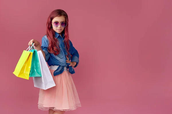 Pequeña niña caucásica sostiene bolsas de compras —  Fotos de Stock