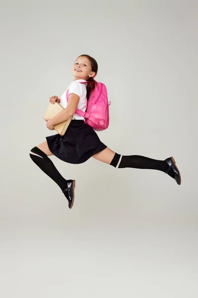 귀여운 여학생 이 배낭을 들고 뛰어올라 — 스톡 사진