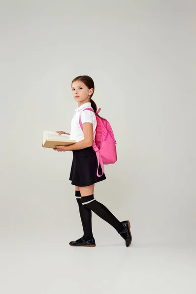 가방 과 책을 활짝 펴고 있는 귀여운 여대생. — 스톡 사진