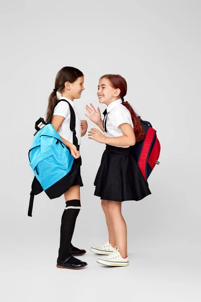 Twee gelukkig weinig vrolijk vrienden schoolmeisjes met rugzakken — Stockfoto