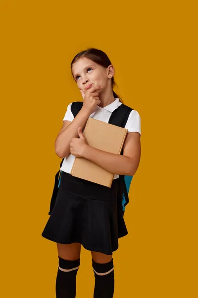 Schattig schoolmeisje met rugzak en boek volledige lengte. — Stockfoto