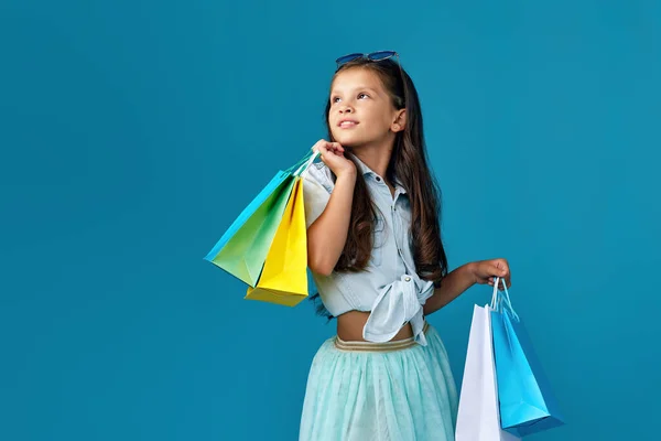 많은 쇼핑백을 들고 있는 행복 한 꼬마 코카서스 소녀 — 스톡 사진