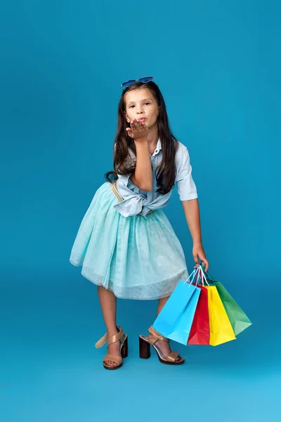 Щаслива маленька біла дівчинка тримає багато сумки для покупок — стокове фото