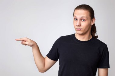 Genç adam boş alanı işaret ediyor.