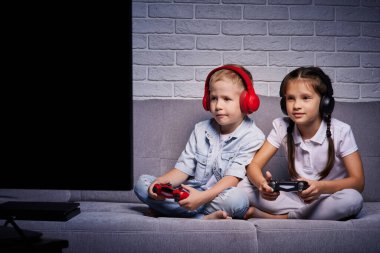Oyun konsoluyla oyun oynayan çocuklar