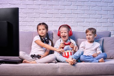 Oyun konsoluyla oyun oynayan çocuklar