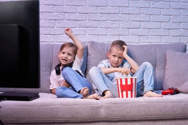 Oyun konsoluyla oyun oynayan çocuklar