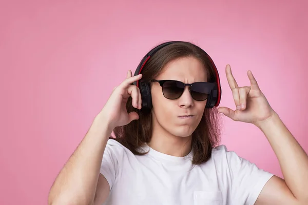 Hombre en gafas de sol escucha música con auriculares y bailes — Foto de Stock