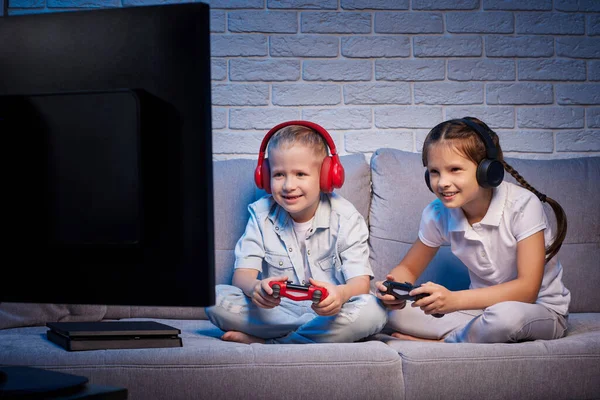 Niños jugando videojuegos con consola de juegos — Foto de Stock