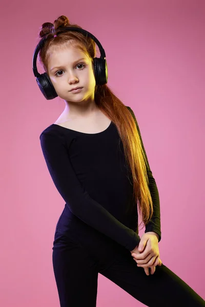 Bambina con occhiali da sole e cuffie che ascolta musica — Foto Stock