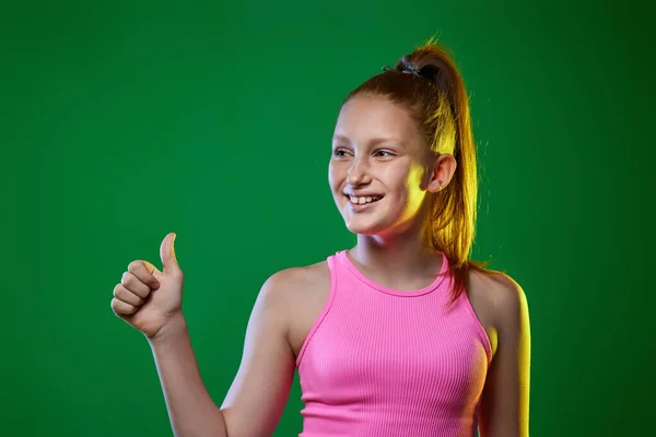 Подросток показывает ОК жест на зеленом фоне. — стоковое фото