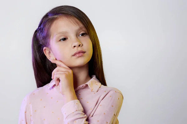 Menina pequena pensativa no fundo branco. — Fotografia de Stock