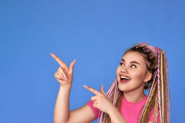 Gülümseyen sarışın kadın işaret ediyor.