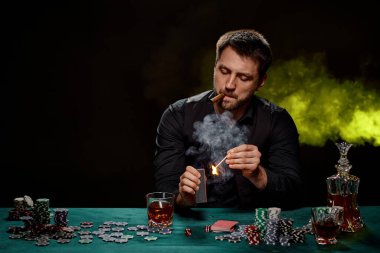 Yeşil masada poker oynayan sakallı kumarbaz.