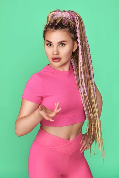 Mujer joven con rastas en ropa deportiva rosa — Foto de Stock