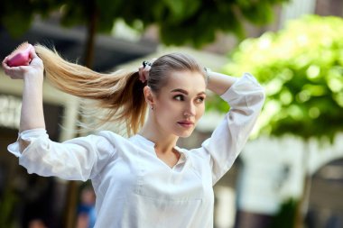 Güzel bir kadın uzun saçlarını fırçayla tarar