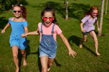 Mutlu şirin çocuklar parkta koşar.