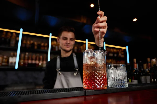 Barman revolviendo cubitos de hielo en copa de cóctel con cuchara —  Fotos de Stock