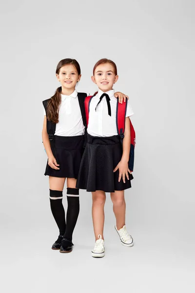 Dois pequenos amigos felizes alunas alegres com mochilas — Fotografia de Stock