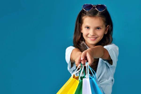 Feliz pequeño caucásico niña sostiene muchos bolsas de compras — Foto de Stock