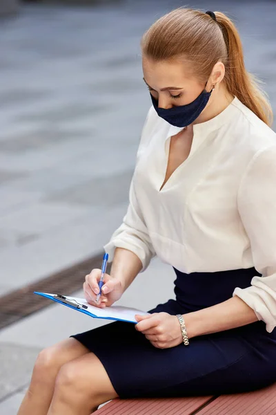 Femme d'affaires dans un masque médical de protection avec presse-papiers — Photo