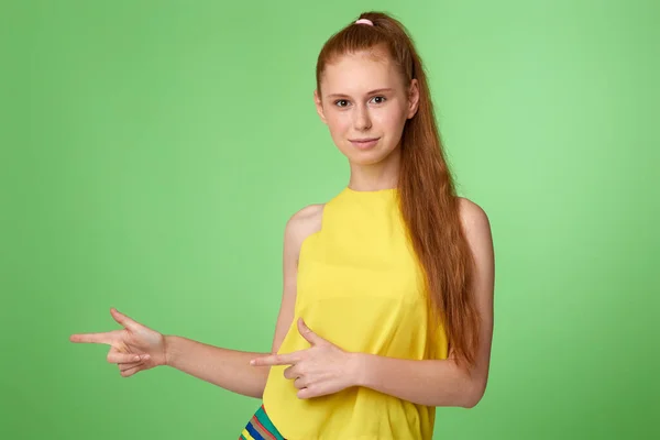 Gelukkig opgewonden blonde vrouw aangeeft vinger lege ruimte — Stockfoto