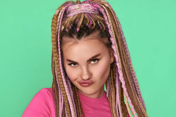 Twijfelende vrouw met dreadlocks op blauwe achtergrond. — Stockfoto