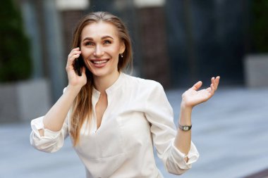 Gözlüklü iş kadını telefonda konuşuyor.