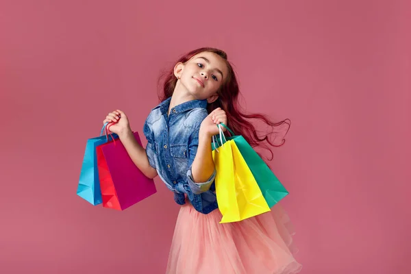 Pequeña niña caucásica sostiene bolsas de compras —  Fotos de Stock