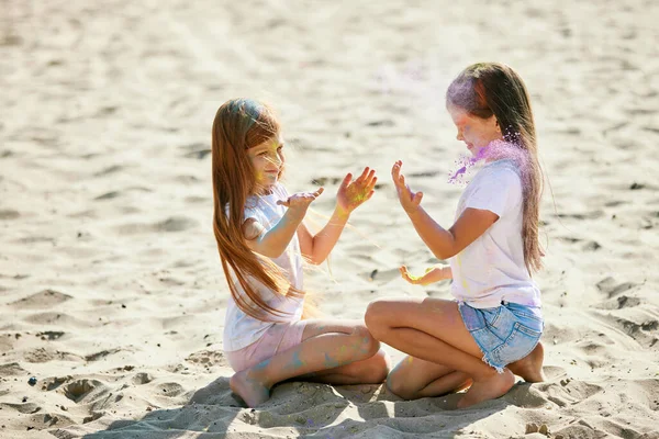 Kind meisjes besmeurd met gekleurde poeder hebben plezier — Stockfoto
