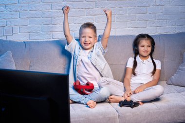 Oyun konsoluyla oyun oynayan çocuklar