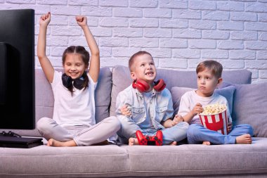 Oyun konsoluyla oyun oynayan çocuklar