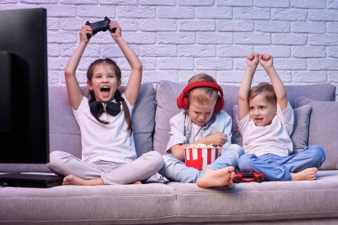 Oyun konsoluyla oyun oynayan çocuklar