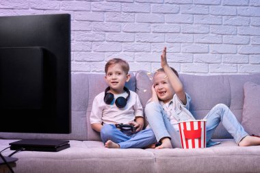 Oyun konsoluyla oyun oynayan çocuklar