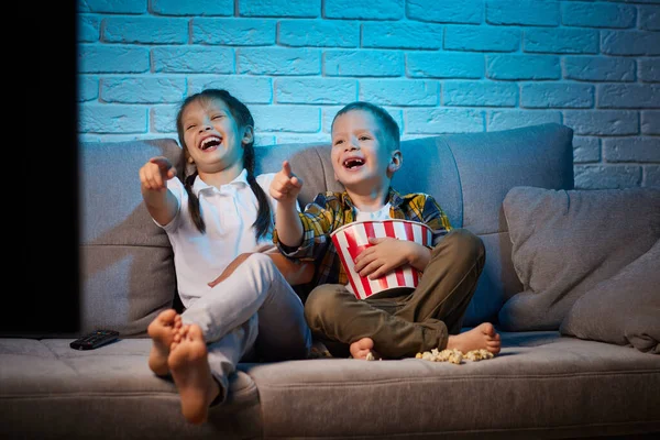 Two children with remote control watching TV — Stock Photo, Image