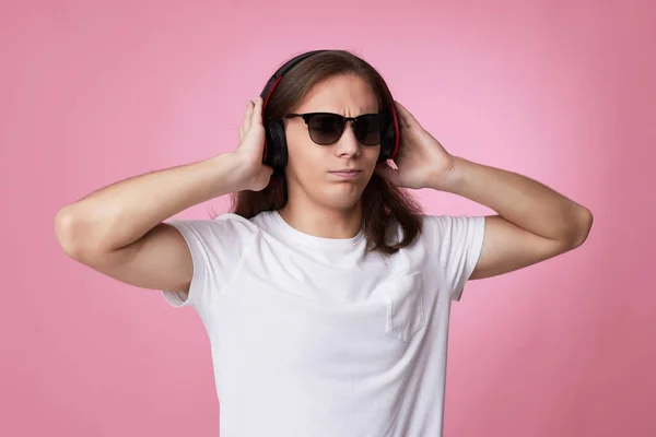 Homem de óculos de sol ouve música com fones de ouvido e danças — Fotografia de Stock