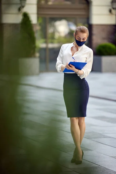 Wanita bisnis dengan topeng medis protektif dengan papan klip — Stok Foto
