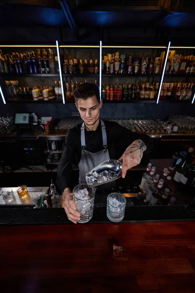 Barman coloca os cubos de gelo em um copo — Fotografia de Stock