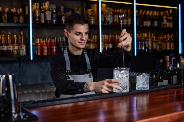 Barman mexendo cubos de gelo em copo de coquetel com colher — Fotografia de Stock