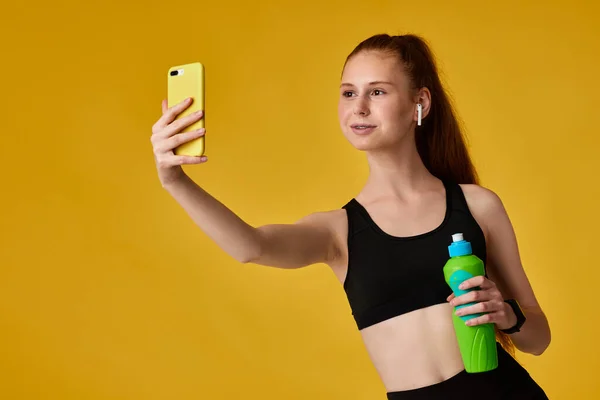 Menina feliz segurando smartphone e tirar uma selfie — Fotografia de Stock
