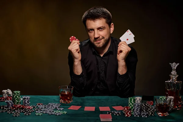 Bearded casino player man playing poker on green table