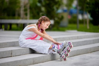 Parkta paten kayan sevimli küçük bir kız..