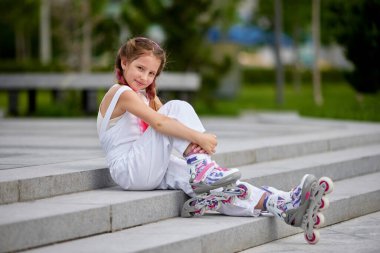 Parkta paten kayan sevimli küçük bir kız..