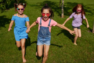 Mutlu şirin çocuklar parkta koşar.