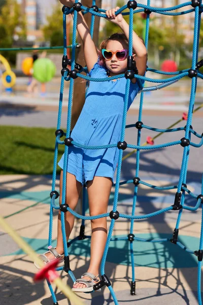 Child girl having fun on playground in sunny day — Stock Photo, Image