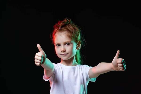 Bambino ragazza mostrando Ok gesto su sfondo nero. — Foto Stock