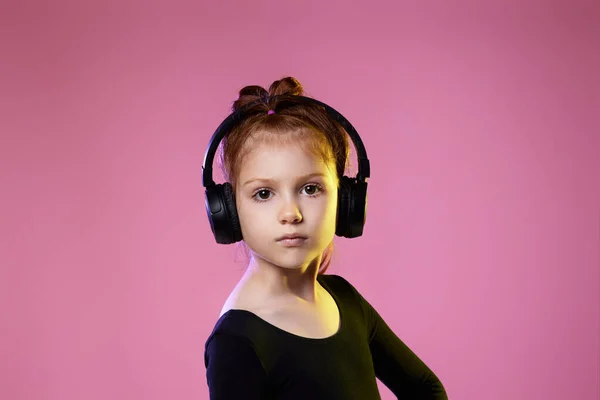 Dziewczynka w okularach przeciwsłonecznych i słuchawkach słuchających muzyki — Zdjęcie stockowe